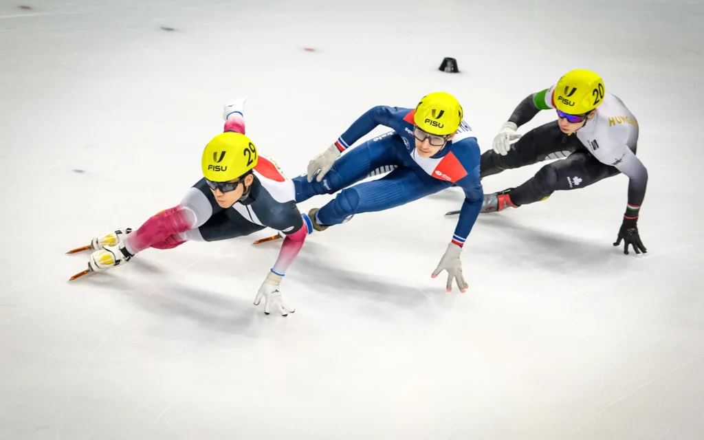 Ecco la traduzione in italiano: Daito Ochi (JPN), Simon Bastier (FRA) e Adam Jozsef Gerecze (HUN) durante i quarti di finale della staffetta mista di Short Track ai FISU Games 2025, i Giochi Mondiali Universitari Invernali di Torino, Italia.