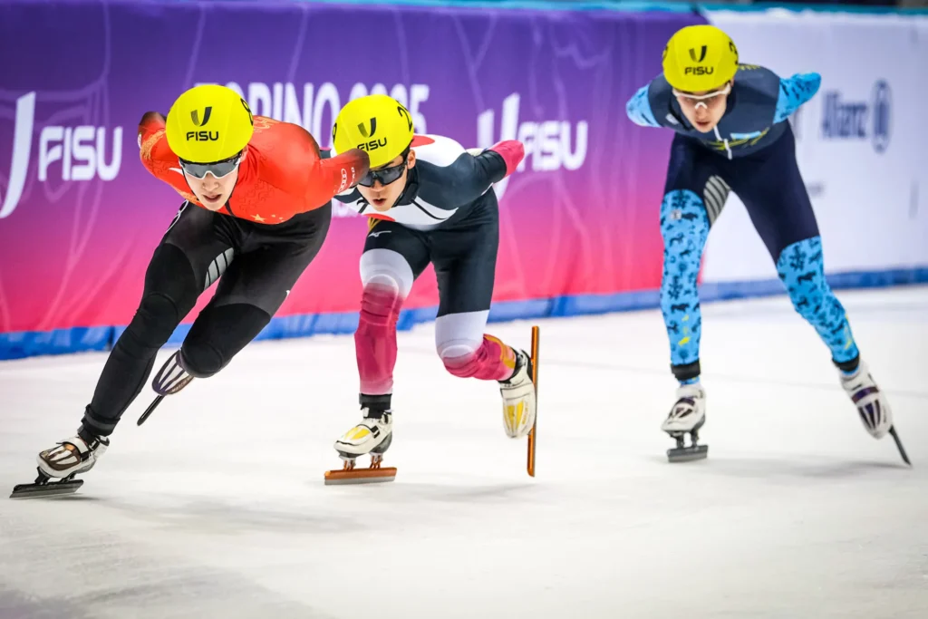 Tiany Zhang (CHN), Daito Ochi (JPN) e Valeiry Klimenko (KAZ) durante la finale A della staffetta 5000 m maschile di Short Track ai FISU Games 2025, i Giochi Mondiali Universitari Invernali di Torino, Italia.